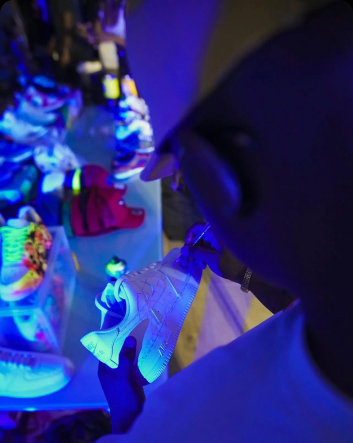 A graffiti artist customising a pair of sneakers